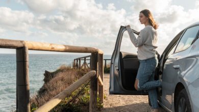 Mulher fazendo uma parada na viagem de carro para tirar uma foto da paisagem